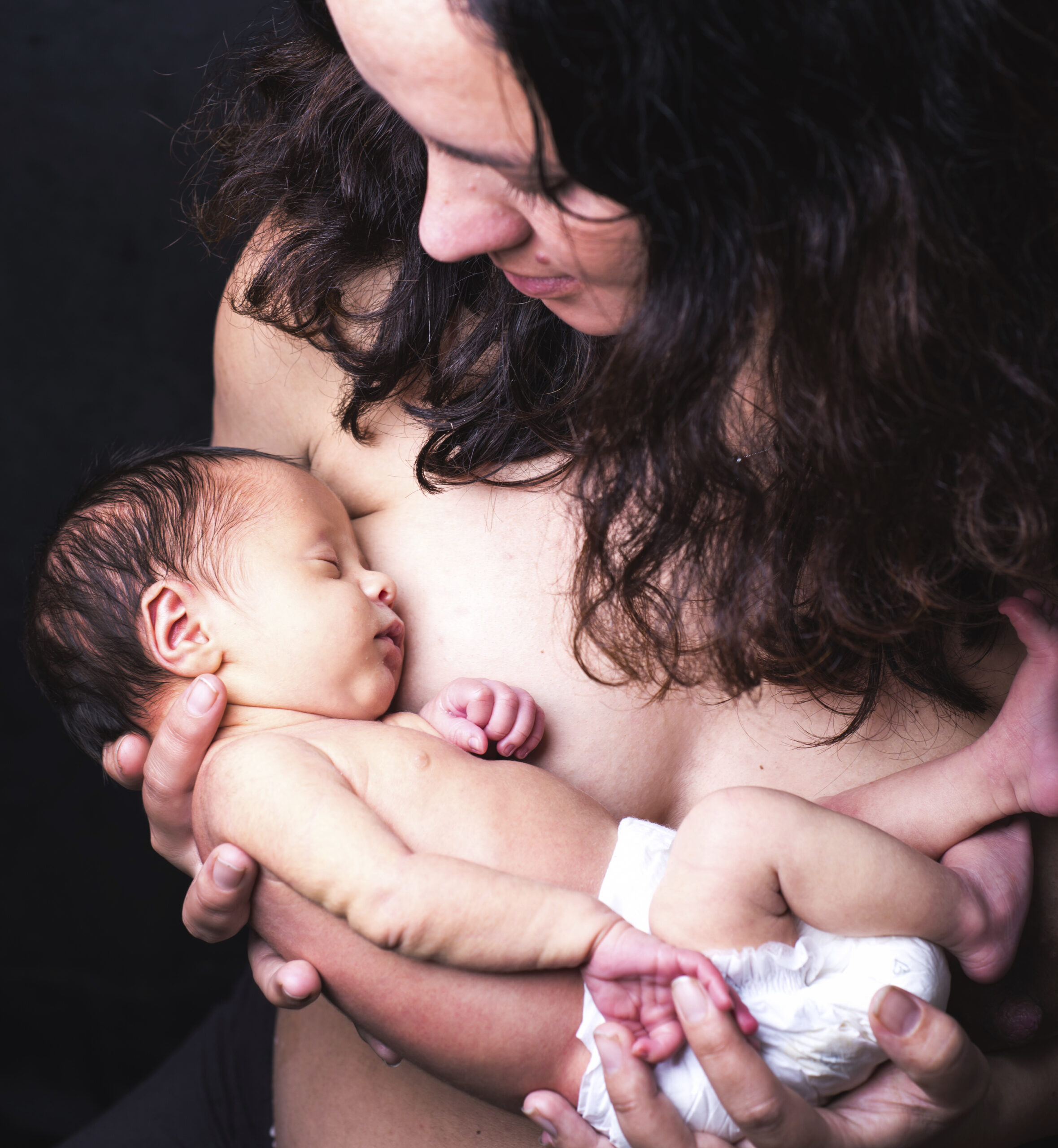 Mid adult mother cradling sleeping baby boy